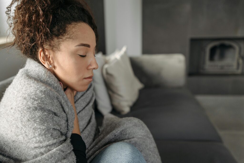 Signs of Heating Issues 1 woman huddled in blanket on couch