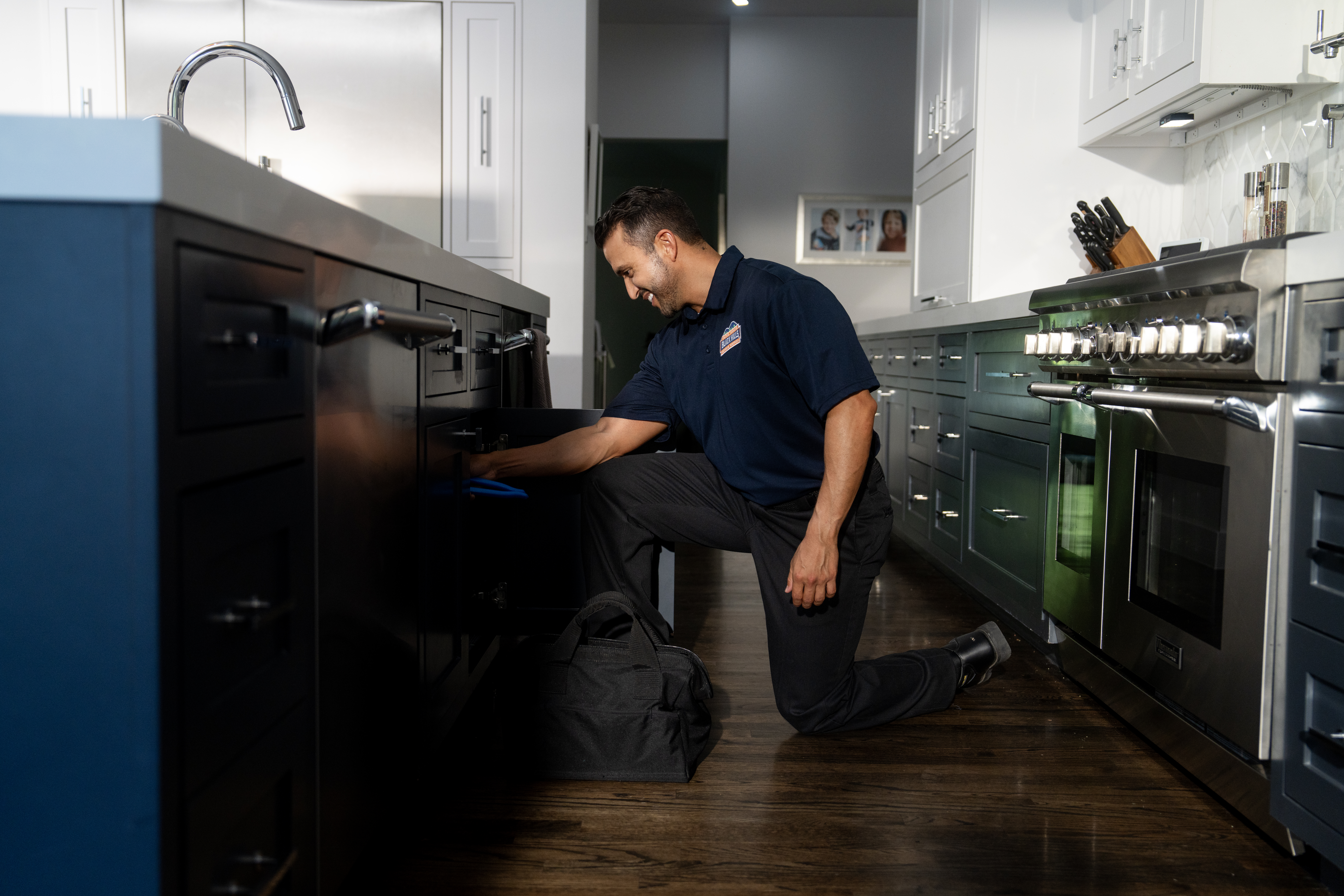 plumber working on kitchen faucet plumbing