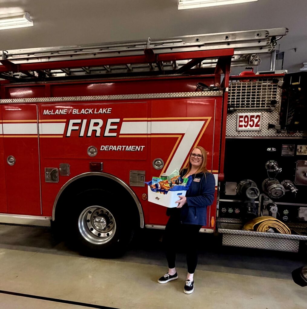 Black Hills staff with snack basket in front of McLane/Black Lake Fire Department truck