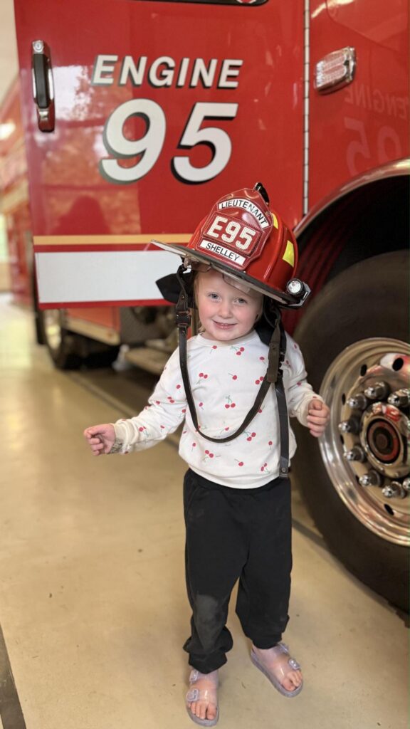 little girl with Engine 95 firefighter hat on