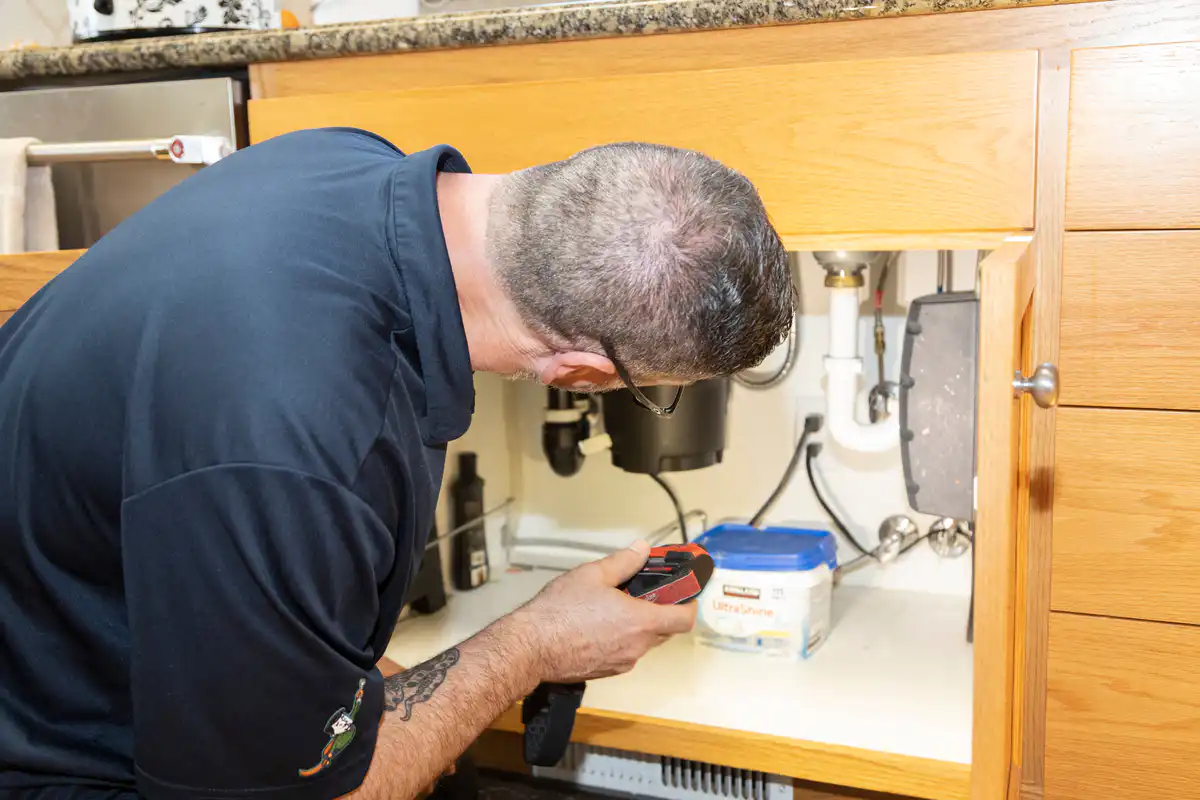 plumber working on garbage disposal system